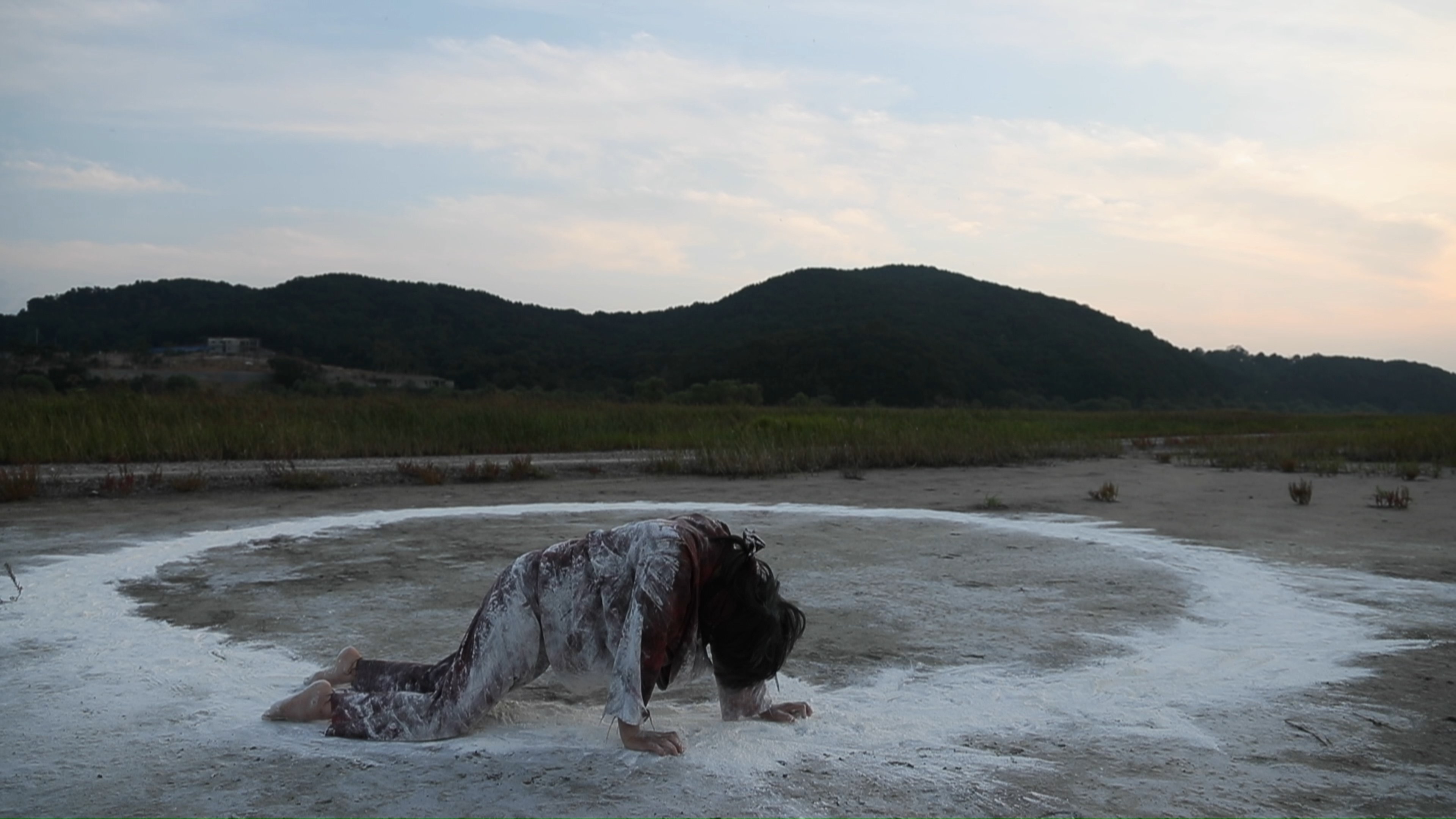 The performer moving toward the ground beside the white circle