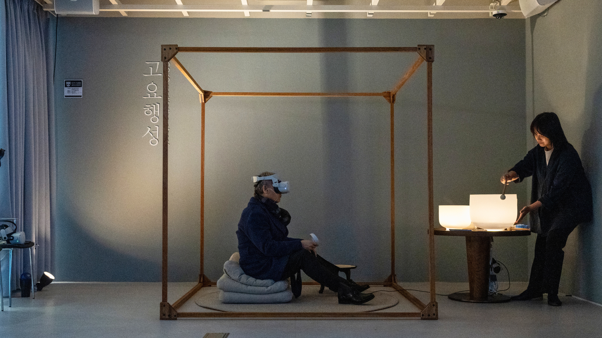 A participant wearing a VR headset while Soojin Pray performs live sound beside the physical GOYO installation