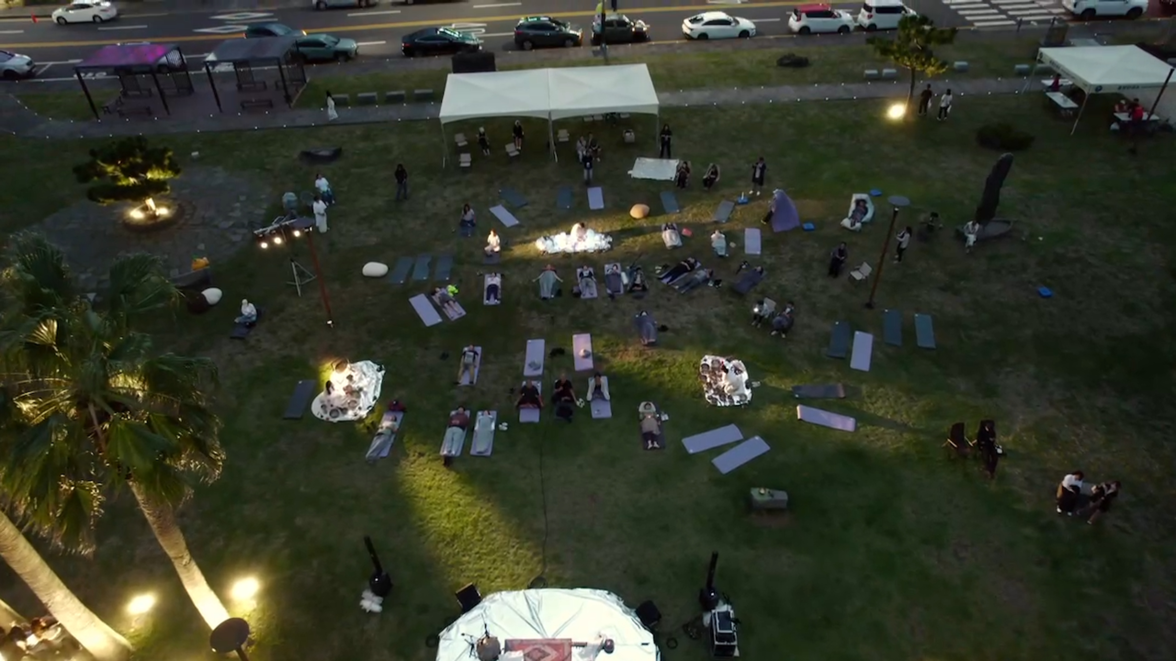 Audience positioned between the coastal park and the surrounding city